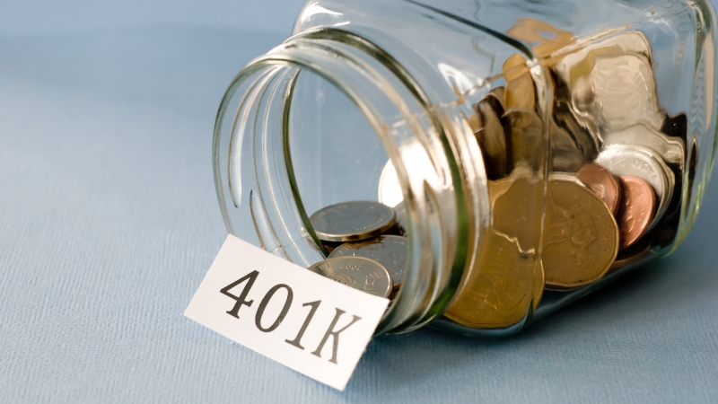 A glass jar with coins and a label marked "401(k)s," symbolizing retirement savings